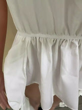 White ruffled skirt with elastic waistband and soft fabric paired with ruffle off-shoulder high-low blouse