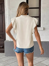 Cream-colored ruffle sleeve tie-neck blouse made of lightweight fabric with ruffled short sleeves and high neckline