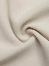 Cream-colored ruffle sleeve tie-neck shirt featuring soft textured fabric with a subtle woven pattern
