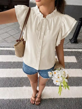 Off-white ruffle sleeve tie-neck blouse with button-down front made of lightweight fabric for elegant wear