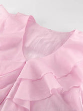 A delicate pink ruffle trimmed long sleeve blouse with soft flowing fabric and layered frills around the neckline