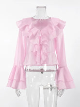 A delicate pink sheer ruffle trimmed long sleeve blouse with layered ruffles at the neckline and flared bell sleeves