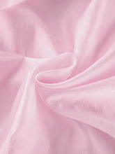 A soft pink silk ruffle trimmed long sleeve blouse with gentle folds and subtle sheen