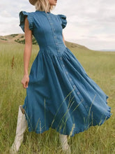 A blue denim dress with ruffled cap sleeves and a button-down front featuring puffed sleeves