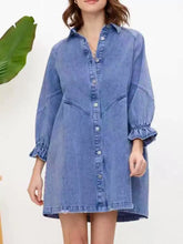 A medium-wash blue denim dress with ruffled cuff button-down design, long sleeves, and a collar