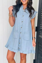 Light blue denim dress with ruffled edge collared sleeves and hem, front button closure, and two patch pockets for machine wash cold