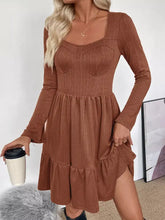 Cozy rust-colored ribbed knit dress with ruffled hem and square neckline