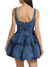 Blue denim dress with corset-style back and tiered ruffle skirt featuring a layered scoop neck design
