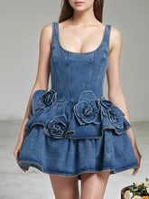 Denim dress featuring a layered scoop neck, corset bodice, and a ruffle skirt with floral appliqués in blue denim