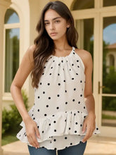 White halter neck cami top with black polka dots and ruffled hem showcasing a ruffled printed halter style