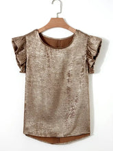 A shimmering gold metallic ruffled round neck tank top with short sleeves hanging on a wooden hanger