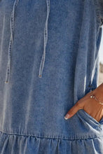 A soft medium-wash denim mini dress with a relaxed fit and subtle ruffled hem featuring puff sleeves