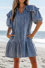 Blue denim mini dress with ruffled sleeves and tiered skirt featuring side pockets and puff sleeves