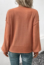 Rust exposed seam sweater with long balloon sleeves and distressed details