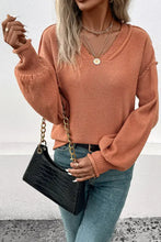 Rust exposed seam sweater with balloon sleeves and textured knit