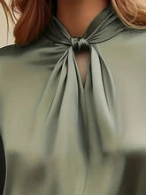 A sleek olive green satin cutout front blouse with a soft knot neckline in luxurious satin fabric
