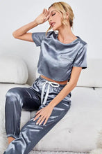 Gray satin short sleeve crop top with front pocket and matching high-waisted joggers tied with white drawstrings