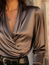 A sleek brown satin surplice long blouse with a deep v-neckline and long sleeves in satin finish