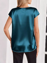A teal satin blouse with short sleeves and a round neckline suitable for elegant casual wear