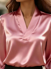 A soft pink satin v neck long sleeve blouse made of smooth satin fabric perfect for elegant occasions