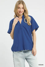 Blue textured blouse with scalloped hem short sleeves and v-neck in a scalloped hem textured design