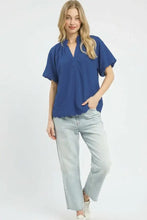 Blue short-sleeved textured blouse with scalloped hem and v-neckline perfect for casual and office wear