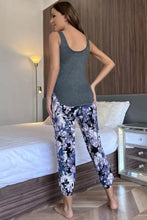 A scoop neck tank and floral cropped pants lounge set featuring capri-length pants with purple and white flowers on navy