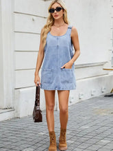 Light blue denim dress with scoop neck wide strap and two front pockets in a sleeveless design