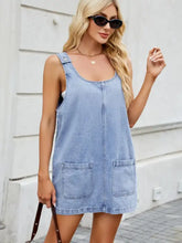 Light blue denim dress with scoop neck wide strap design featuring two front pockets and adjustable shoulder straps