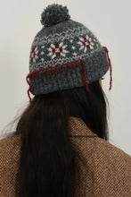 Gray geometric knit hat with seam trim, pom-pom, and snowflake pattern