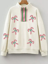Cream-colored half-zip sweatshirt with embroidered red and white candy canes and green holly, machine wash and tumble dry