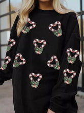 Black corduroy sequin Christmas candy cane heart sweatshirt with green bow embellishments and care instructions detail