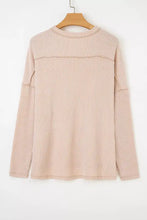Soft blush pink ribbed long sleeve top with subtle vertical stripes relaxed fit and exposed seam for machine wash care