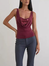 A maroon velvet tank with a draped cowl neck and ruched sequin detail on the bodice