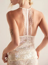 Ivory halter neck cami featuring delicate lace trim, a sequined bodice, and an open back with intricate lace patterns