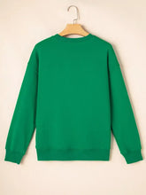Solid green long-sleeved crewneck sweatshirt with sequin letter graphic father christmas patched sleeve machine wash tumble dry care instructions