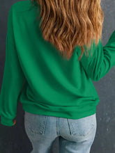 A vibrant green sequin letter graphic father Christmas patched sleeve sweatshirt with ribbed cuffs and machine wash care instructions