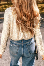 Gold sequin long sleeve wrap bodysuit with bell sleeves and distressed denim jeans