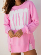 Pink oversized baggy sweatshirt with sequin xoxo lettering and distressed details made from slightly stretchy fabric