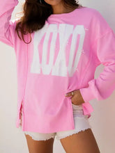 Pink slightly stretchy long-sleeved baggy sweatshirt with sequin xoxo lettering and decorative stitching details care instructions included