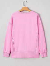 Pink sequin xoxo letter graphic baggy sweatshirt with ribbed cuffs hem slightly stretchy fabric and exposed seams