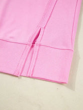 Pink ribbed knit hem with side slit detail on slightly stretchy sequin xoxo letter graphic baggy sweatshirt with care instructions