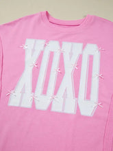 Pink cotton slightly stretchy sweatshirt with bold white sequin xoxo graphic and tiny pink bows care instructions included