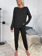 Black shiny round neck top and drawstring pants lounge set with elastic cuffs and relaxed fit in long sleeves