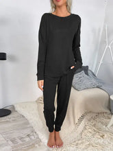 Black long-sleeved shiny round neck top and drawstring pants lounge set with relaxed fit and elastic cuffs