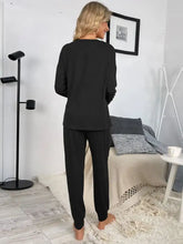 Black shiny round neck top and drawstring pants lounge set with long sleeves and relaxed tapered fit pants