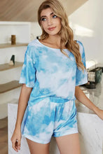 Blue and white tie-dye two-piece loungewear set featuring a shiny boat neck top with short sleeve length and matching shorts