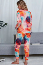 A vibrant shiny tie-dye crewneck top and joggers lounge set with long sleeve length in orange pink blue and purple