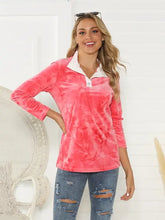 Woman in shiny tie-dye half button long sleeve T-shirt with ripped jeans