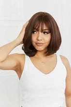 Woman in short brown bob synthetic wig with bangs and white tank top, cap included